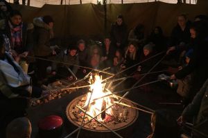 Schüler am Lagerfeuer mit Stockbrot
