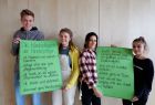 Schüler halten selbst gemalte Plakate hoch